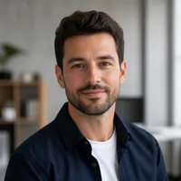 Professional author portrait of a neutral-gender adult with smart casual attire, set against a blurred office background.